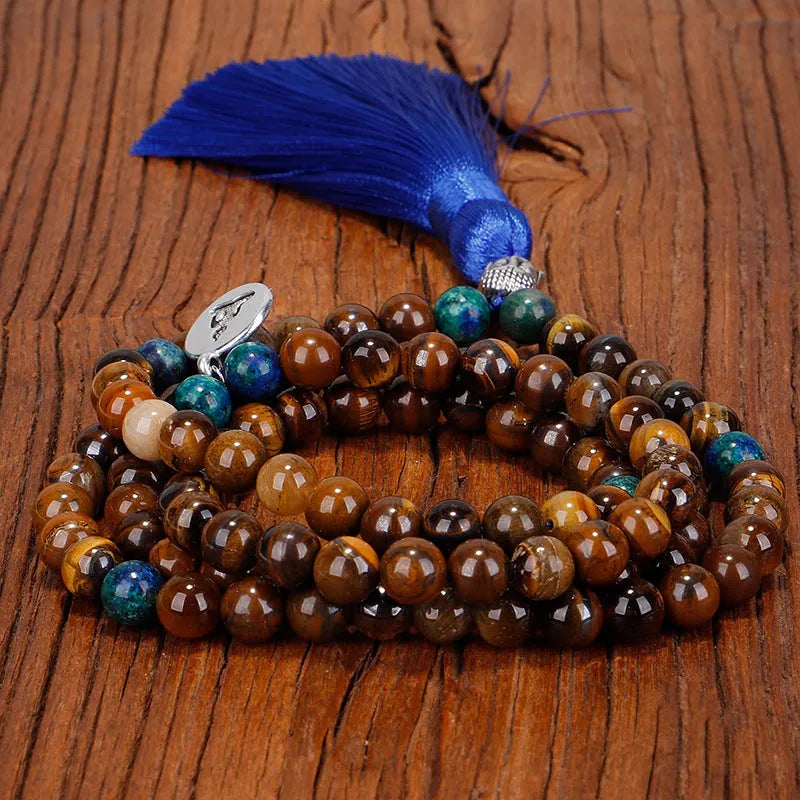 Handmade tiger eye stone bead necklace with tassel pendant and matching bracelet on a neutral background