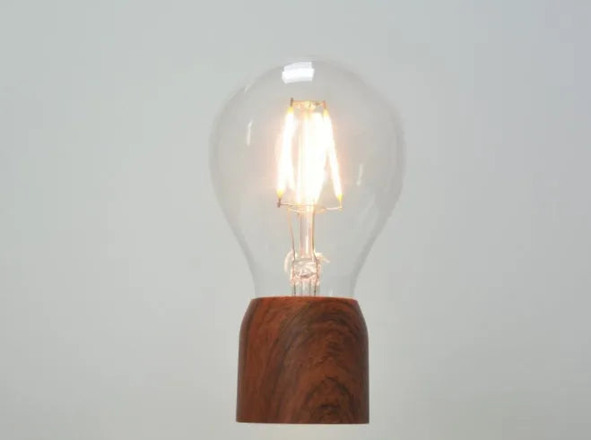 Magnetic levitation floating bulb lamp with imitation wood base and glass construction