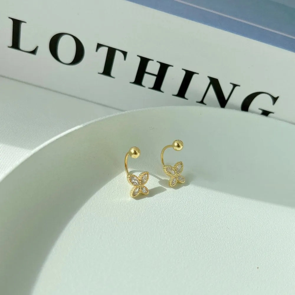 Pair of S925 silver bow-shaped ear hook earrings in gold finish on simple background