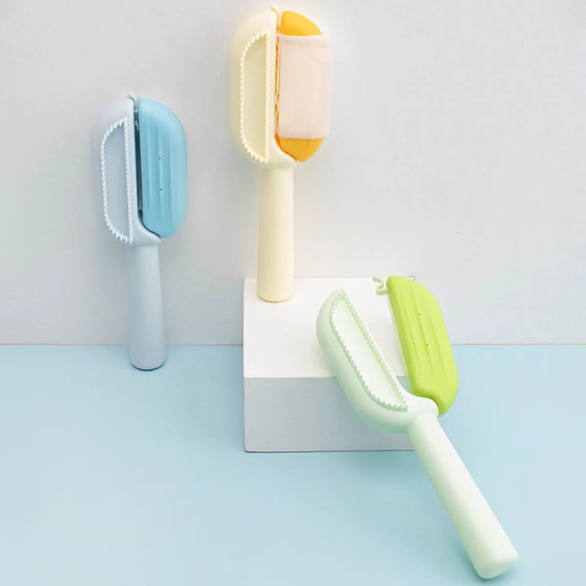 Blue pet grooming comb with a water tank for catching floating hair, shown alongside a soft cotton towel.