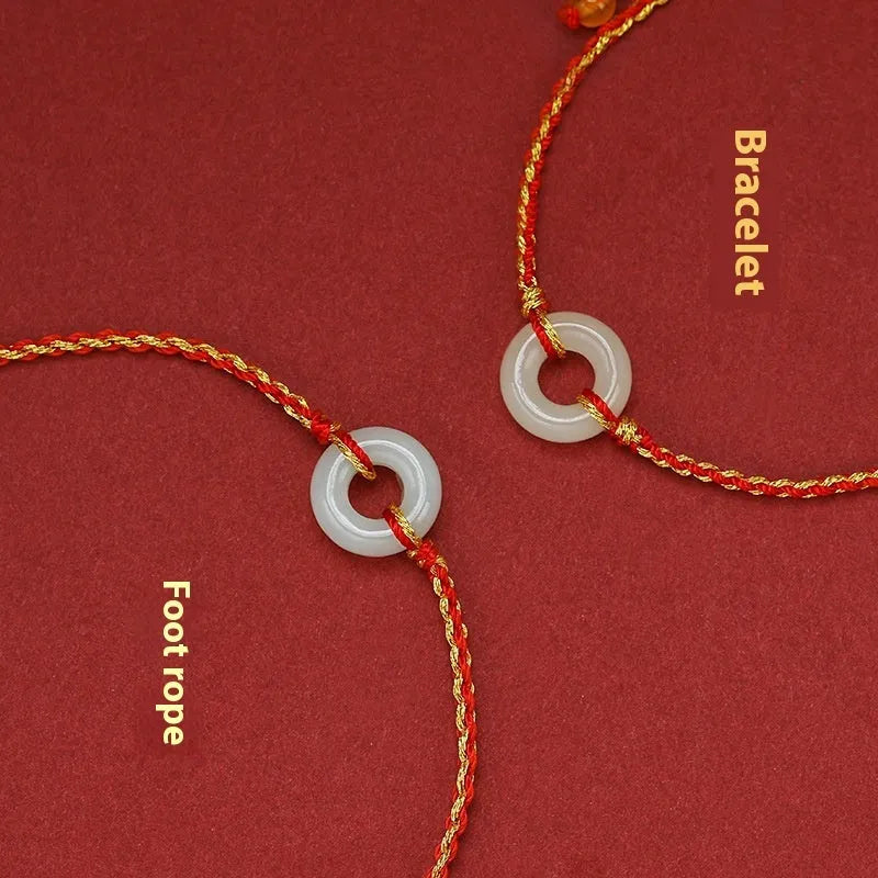 Red rope braided bracelet with natural wave-shaped Hetian jade pendant for Tiger Year birth year, on a neutral background