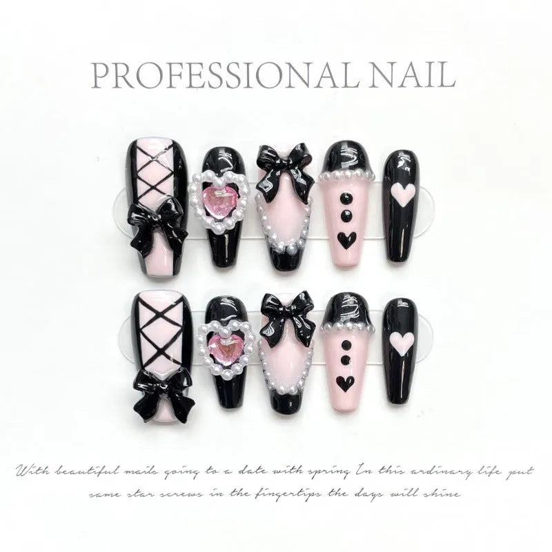 Hand-painted black and peach heart-shaped press-on nails with a cat's eye shine, shown in a set.