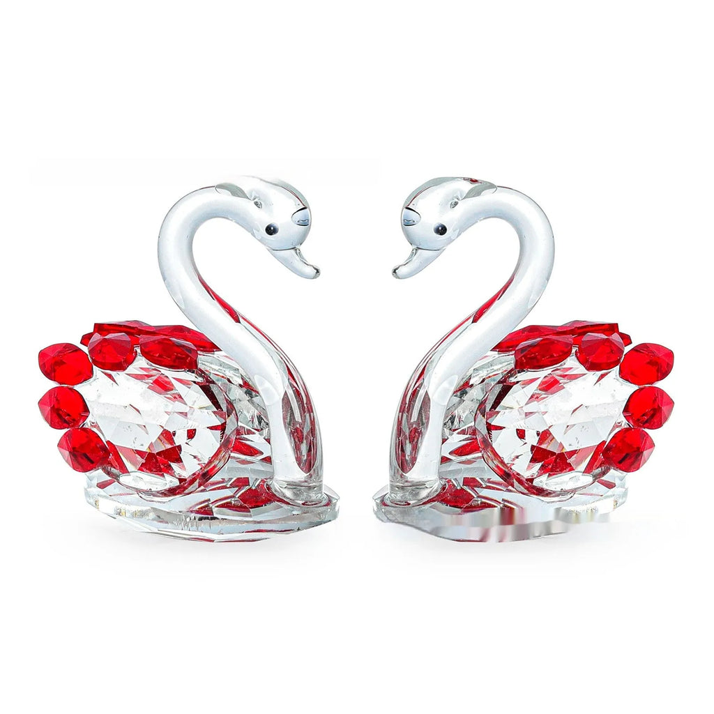 White crystal swan decoration on a desktop in solid head and empty tube styles.