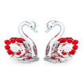 White crystal swan decoration on a desktop in solid head and empty tube styles.