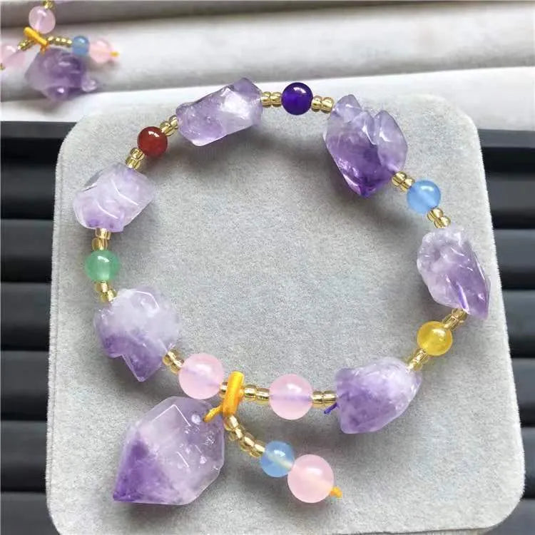 A women's bracelet made of purple natural amethyst beads with a fu character charm.