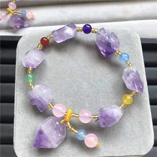 A women's bracelet made of purple natural amethyst beads with a fu character charm.