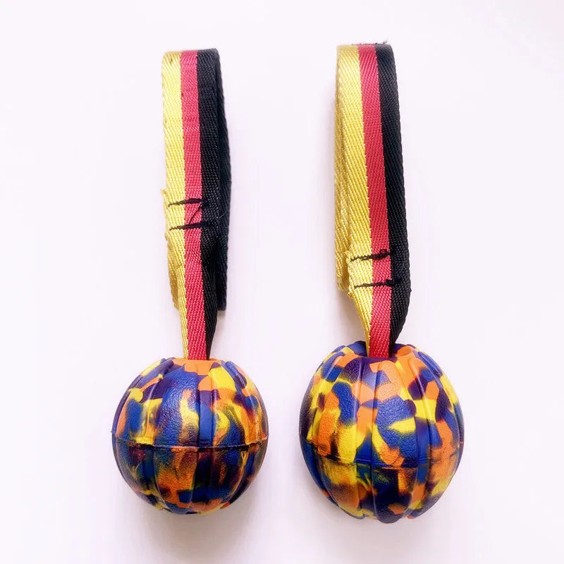 Yellow and camouflage coloured EVA foam floating dog tether balls in three different sizes on a blue background.