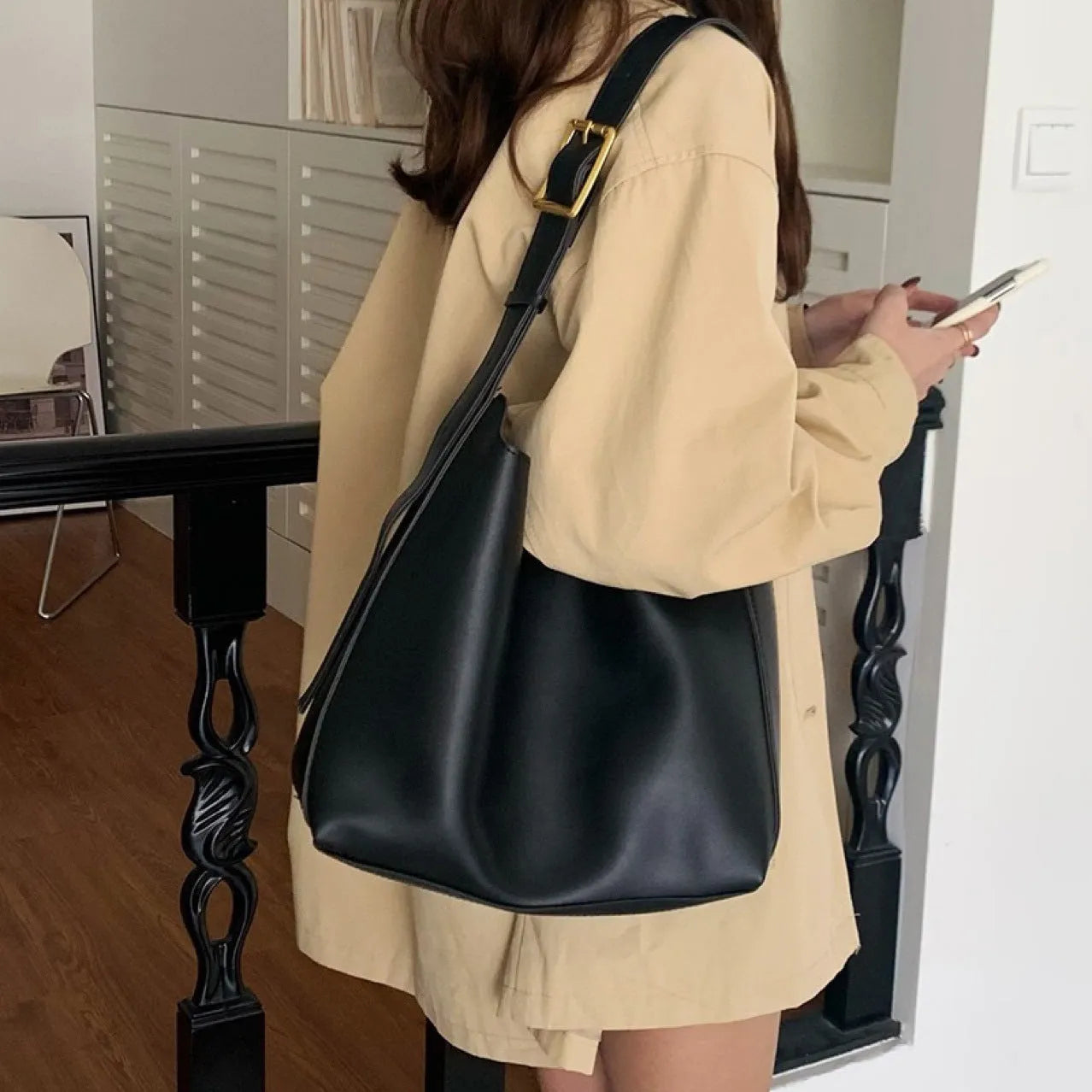 Two women's soft PU leather shoulder bags with swing threads, one black with ribbon and one brown with packet design
