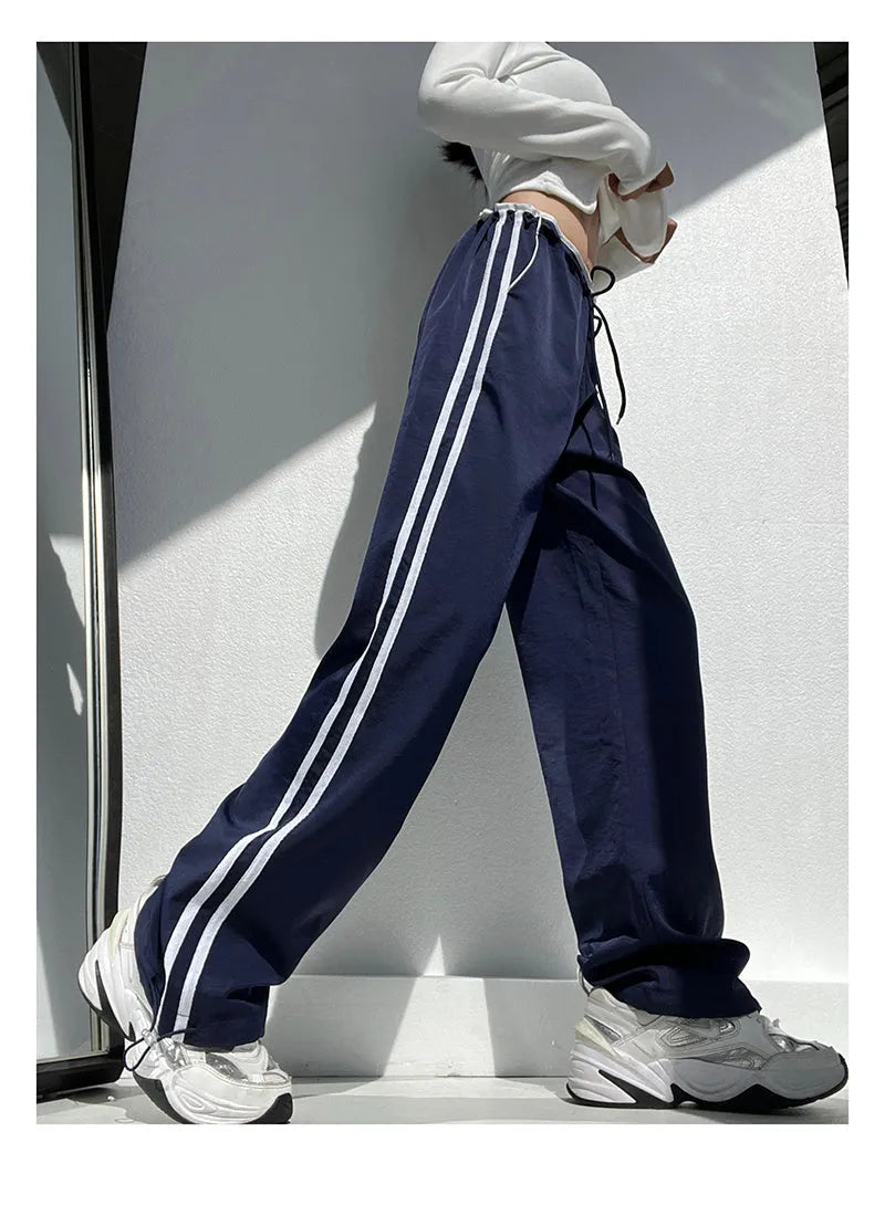 Women's navy blue straight leg trousers with a low waist and slimming drape.
