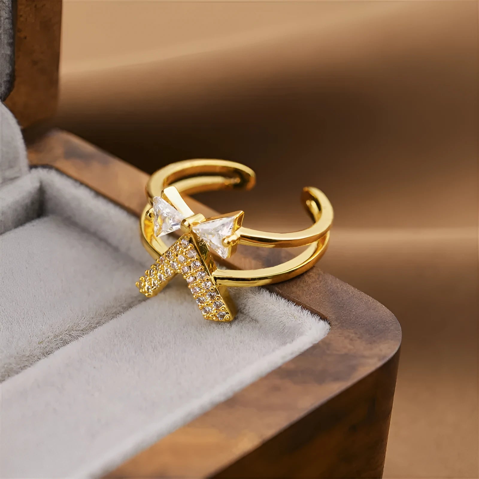 Gold geometric open fashion ring for women on a plain background.