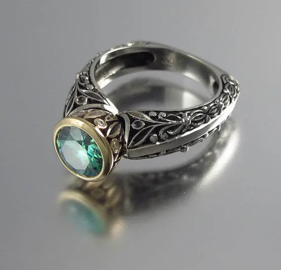 Green silver gold-plated flower-shaped vintage ring with colour separation design on a neutral background