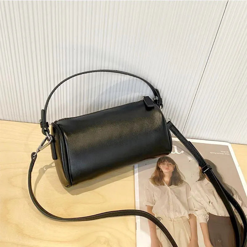 Soft brown genuine leather cylindrical crossbody phone bag with adjustable strap.
