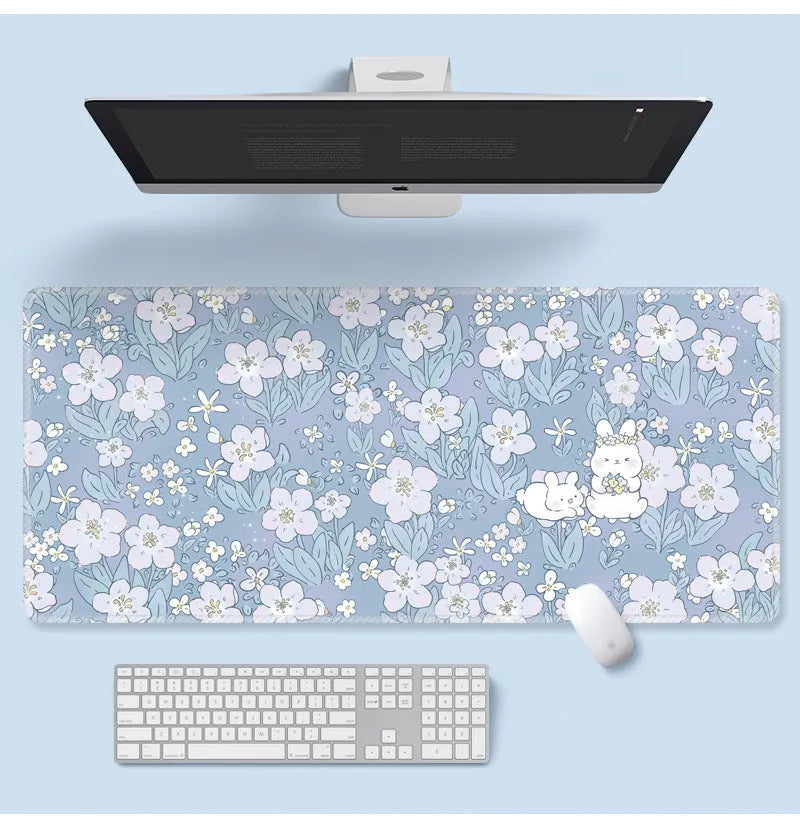 Large floral pattern mouse pad on a desk with keyboard and mouse, showing non-slip rubber base.