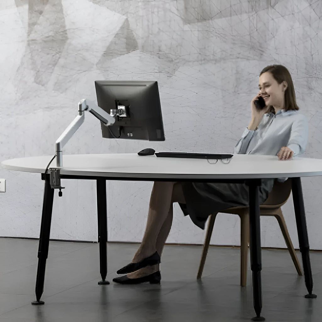 Silver aluminium laptop stand with adjustable air pressure arm on wooden desk