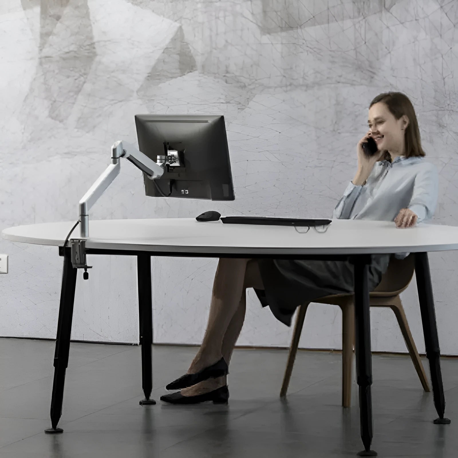 Silver aluminium laptop stand with adjustable air pressure arm on wooden desk