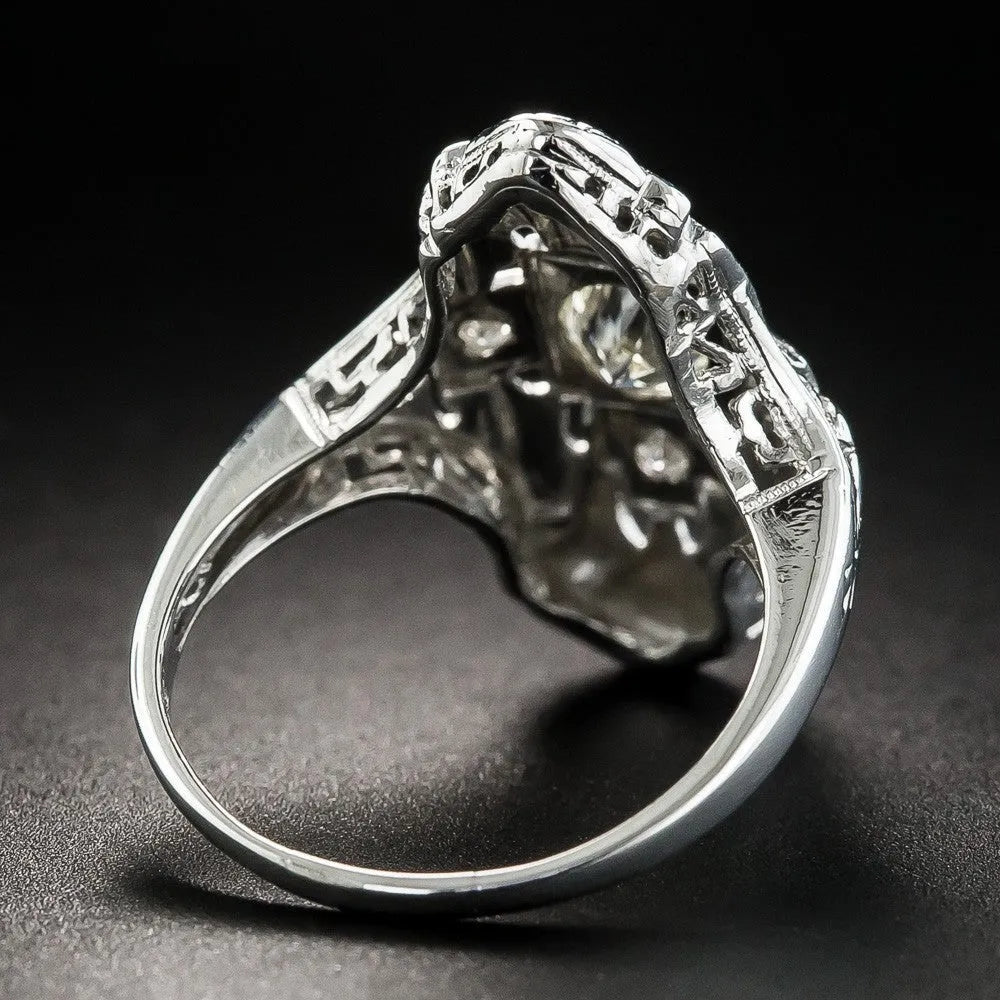 Geometric hollow-out silver ring with diamond studs on a finger.