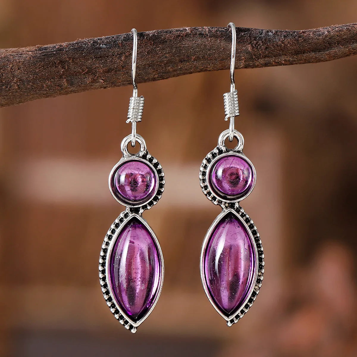 A pair of geometric vintage pendant earrings in black and purple colours with a bohemian style.