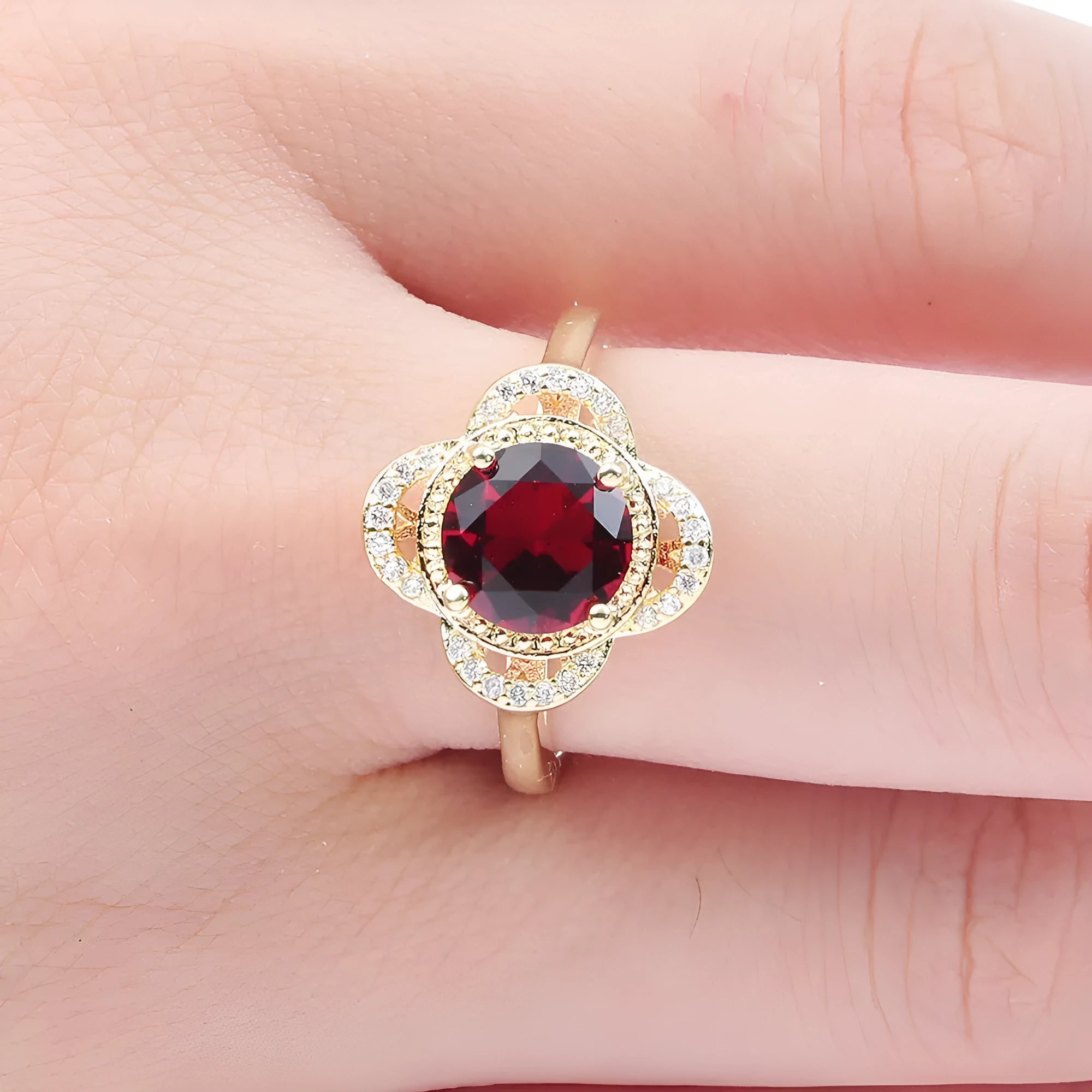 Copper ring with a zircon stone inlay in a fruit shape design on a finger.