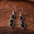 A pair of geometric vintage pendant earrings in black and purple colours with a bohemian style.