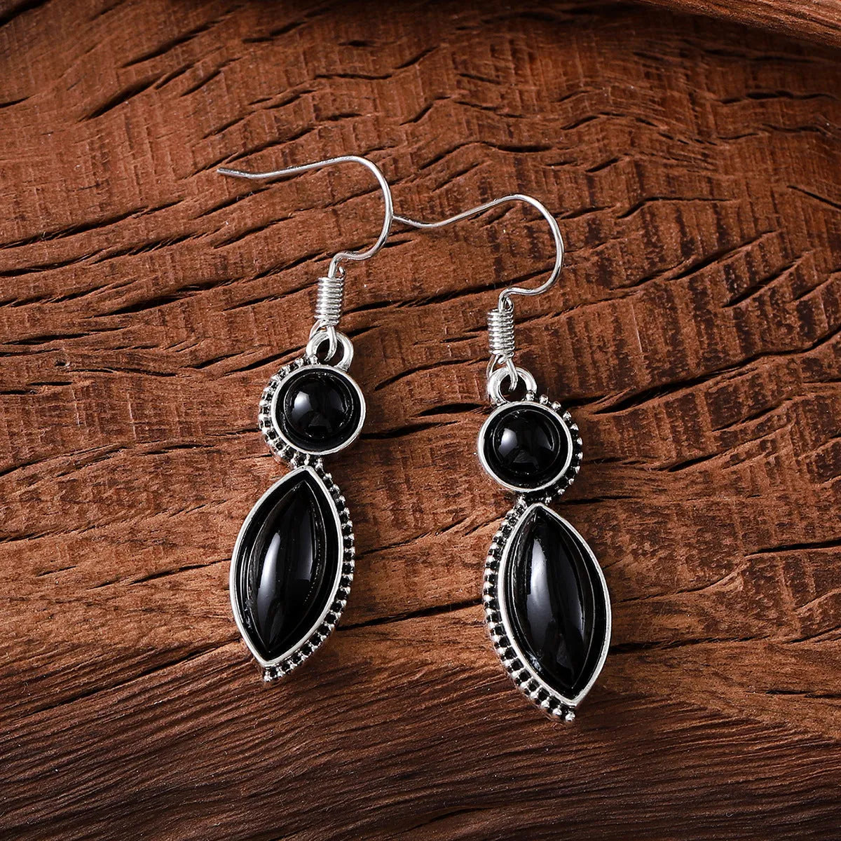 A pair of geometric vintage pendant earrings in black and purple colours with a bohemian style.