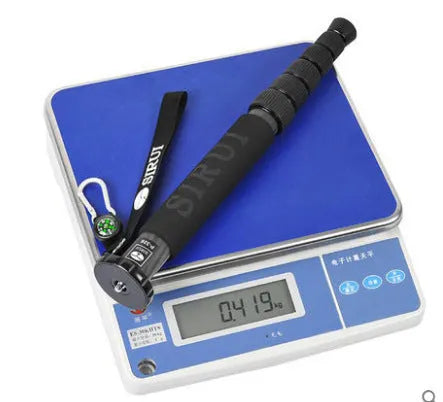 Black carbon fibre SLR camera monopod extended to maximum height with six visible sections