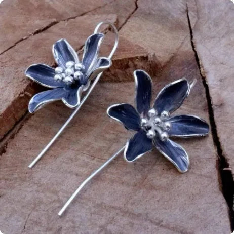 A pair of purple flower-shaped alloy earrings with an electroplated finish.