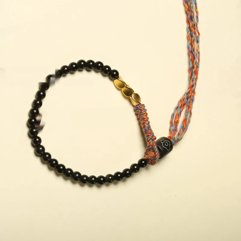 Hand-woven obsidian carrying strap bracelet with a stone bead, showing its 4mm width and adjustable length.