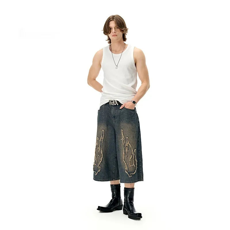 Men's black denim cropped shorts with flame embroidery patch design on leg