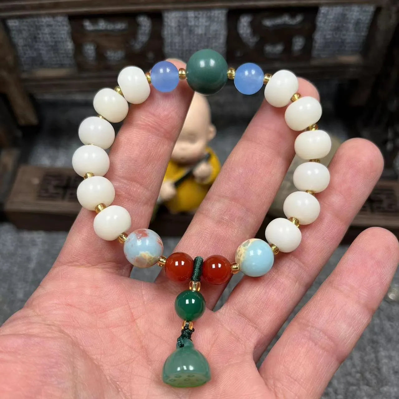 Carved Bodhi root bracelet with white jade, lotus, and pumpkin beads in various sizes.