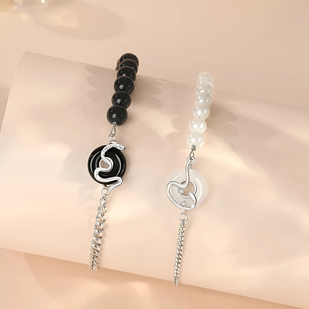 925 sterling silver bracelet with snake charm, obsidian pearl, and safe buckle closure on a wrist.