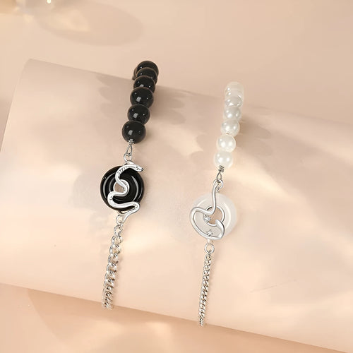 925 sterling silver bracelet with snake charm, obsidian pearl, and safe buckle closure on a wrist.