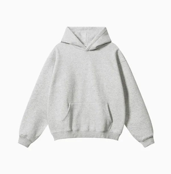 Man wearing a grey heavyweight cotton terry hooded sweater with a loose fit and drop-shoulder sleeves.