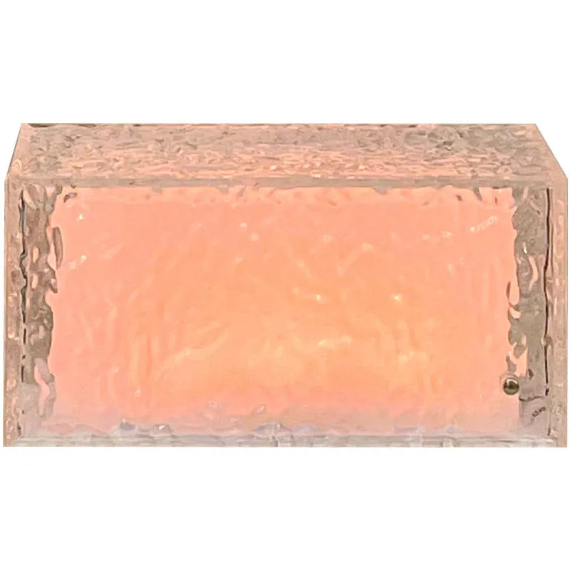 Clear acrylic geometric ice cube shaped night lamp glowing with multi-coloured LED light on a dark surface.
