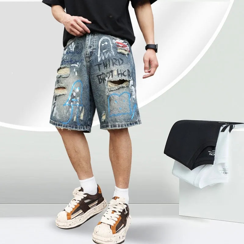 Blue men's ripped denim shorts with graffiti detailing and a straight-leg cut, showing front zipper fly.