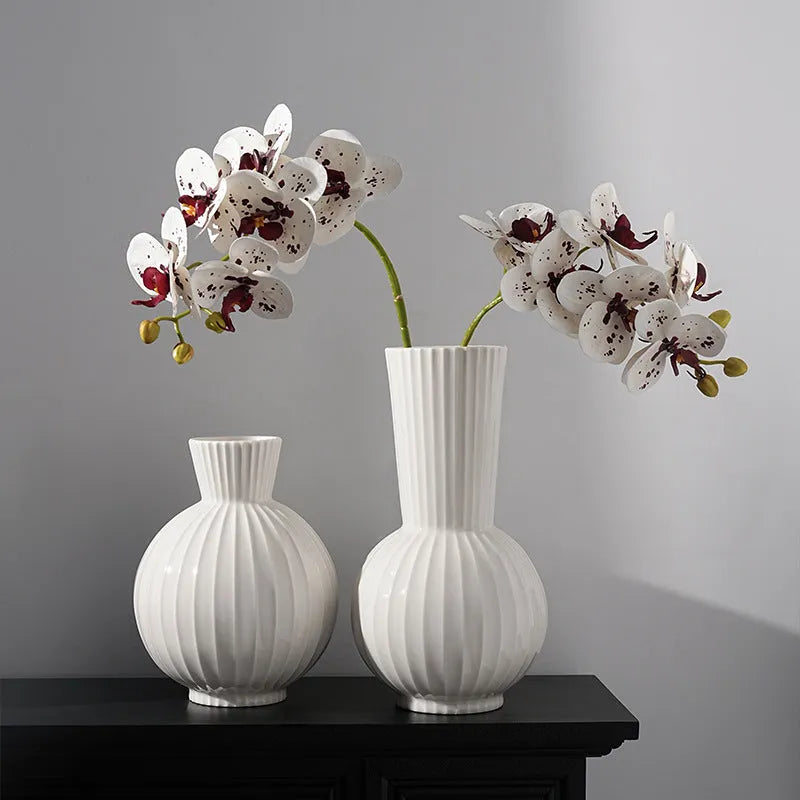 White ceramic ball vase with blue stripes on wooden table