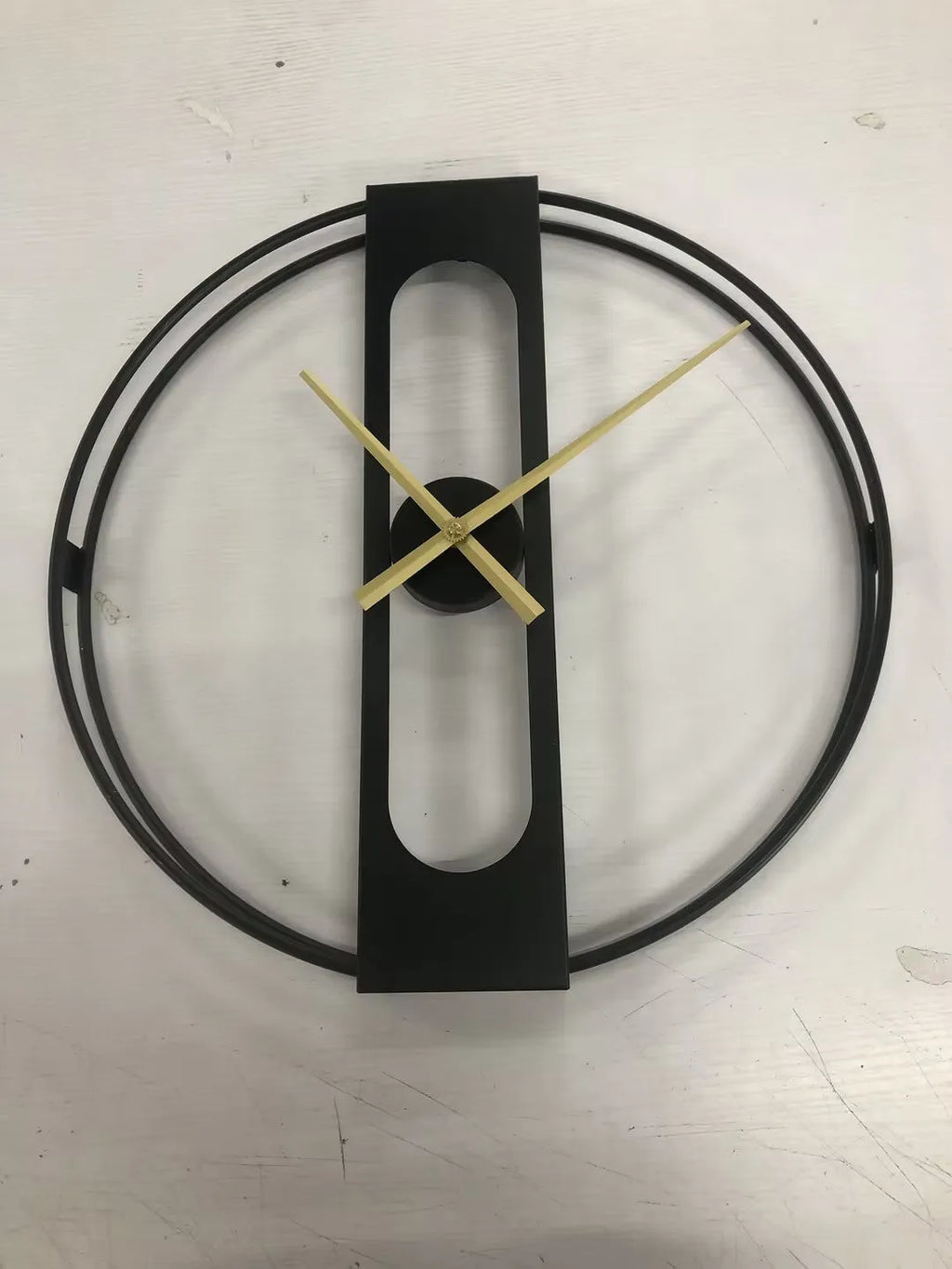 Round metal wall clock with 50cm diameter in black or gold finish on a wall