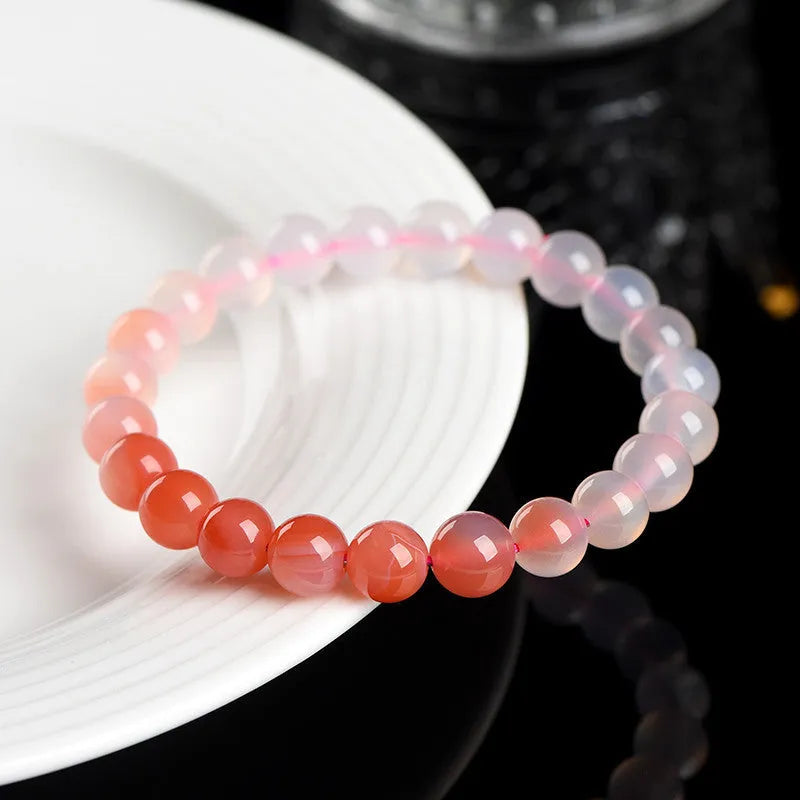Natural gradient Yanyuan agate bracelet with geometry-shaped beads on a wrist.