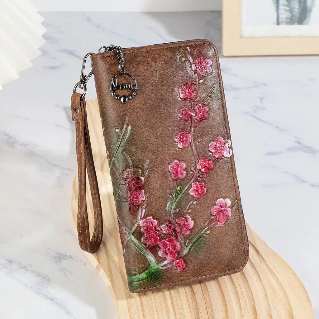 Retro brown handbag with embossed floral design and a large metal YKK zipper.