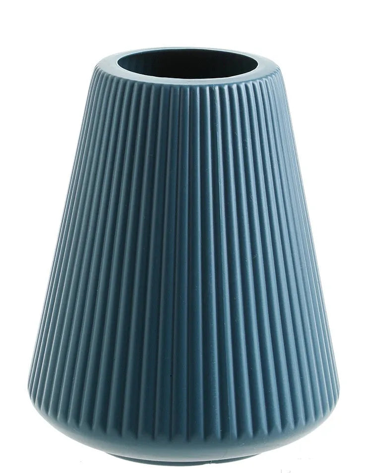 Blue melamine plastic decorative flower vase on a wooden desktop.