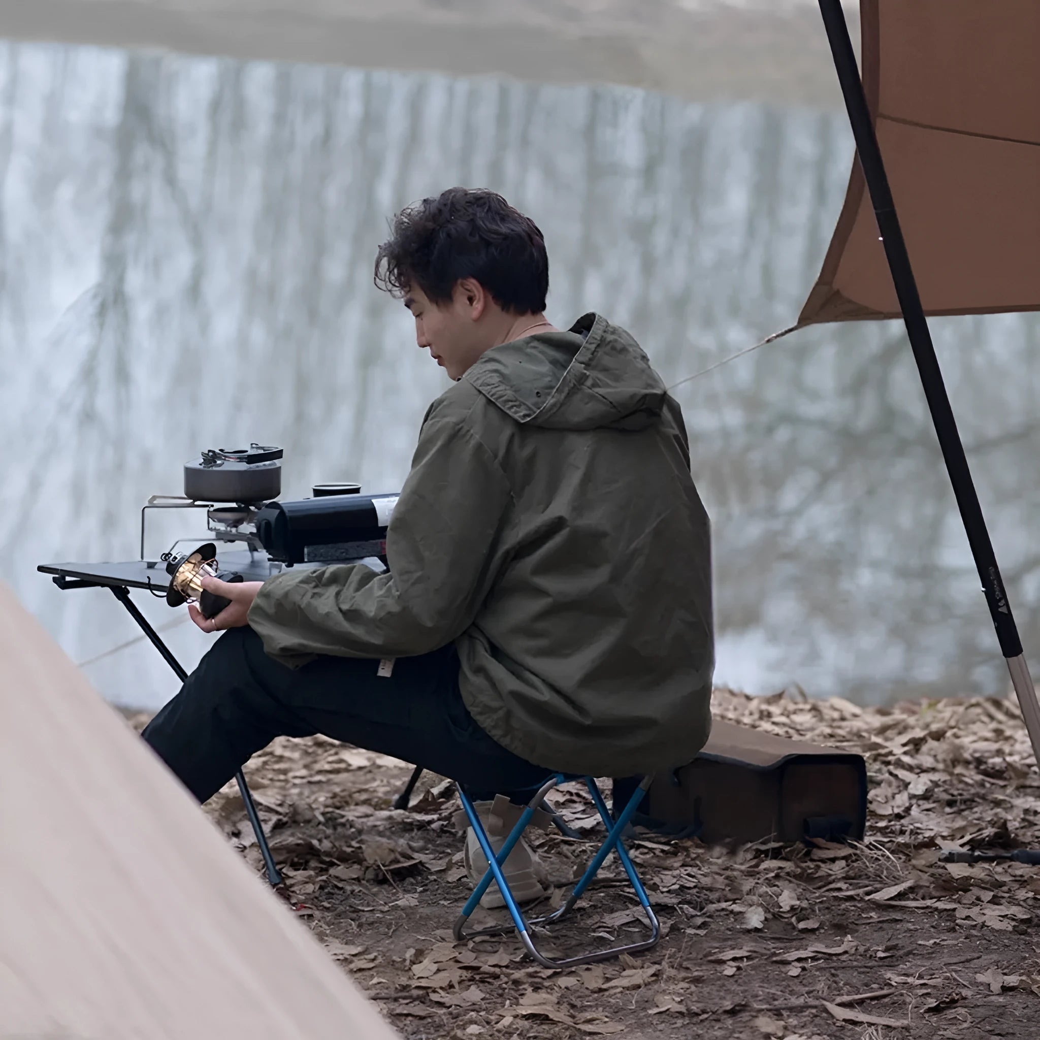 Black aluminium alloy folding camp stool shown in open and folded positions for portable outdoor seating.