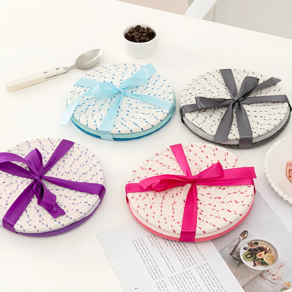 Set of three round grey cotton cord coasters, each 18 cm in diameter, on a wooden table.