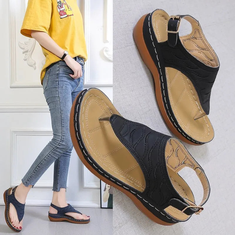 Women's wedge heel flip flop sandals in black with an adjustable buckle strap on the back.