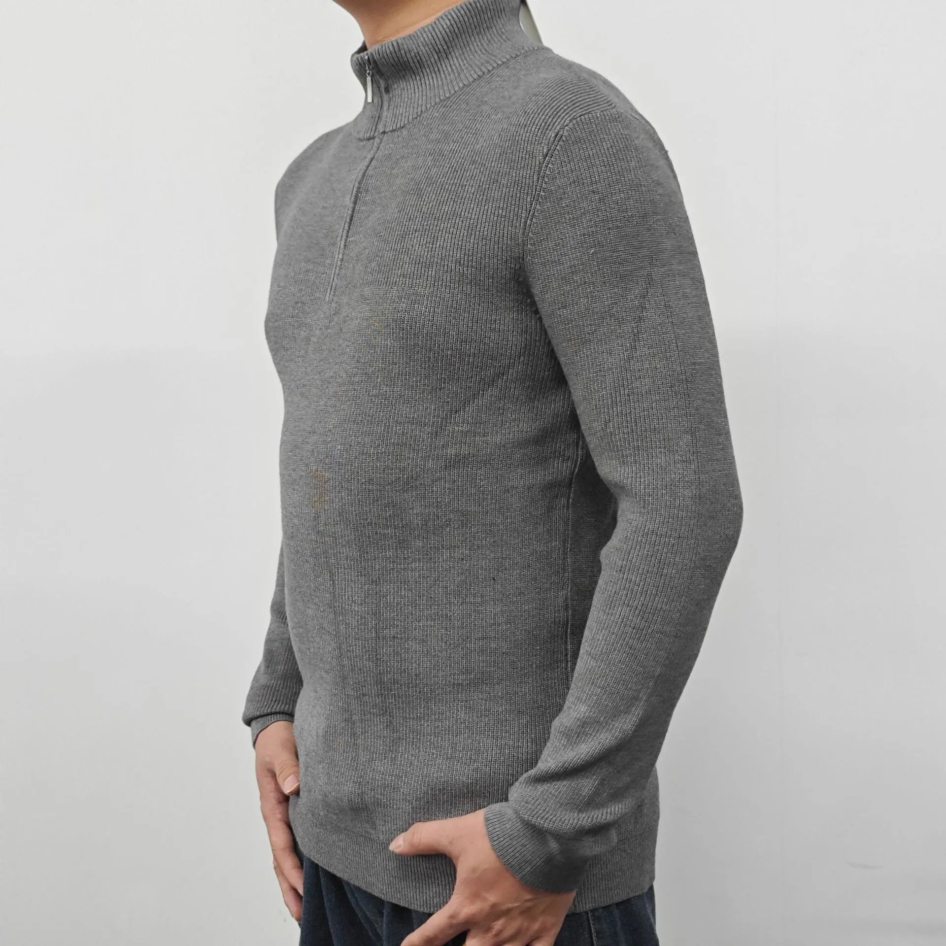 Man wearing a grey half turtleneck zipper sweater, a British style cotton blend pullover for spring.