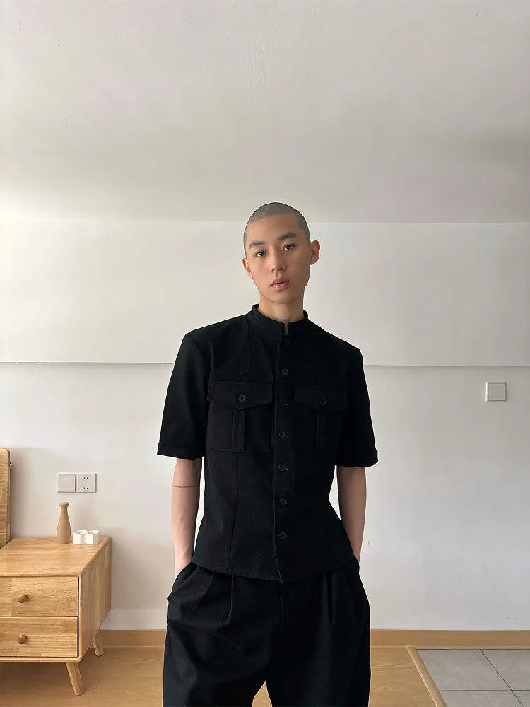 Black handmade loose fit half sleeve hunting shirt with a traditional shirt collar on a hanger.