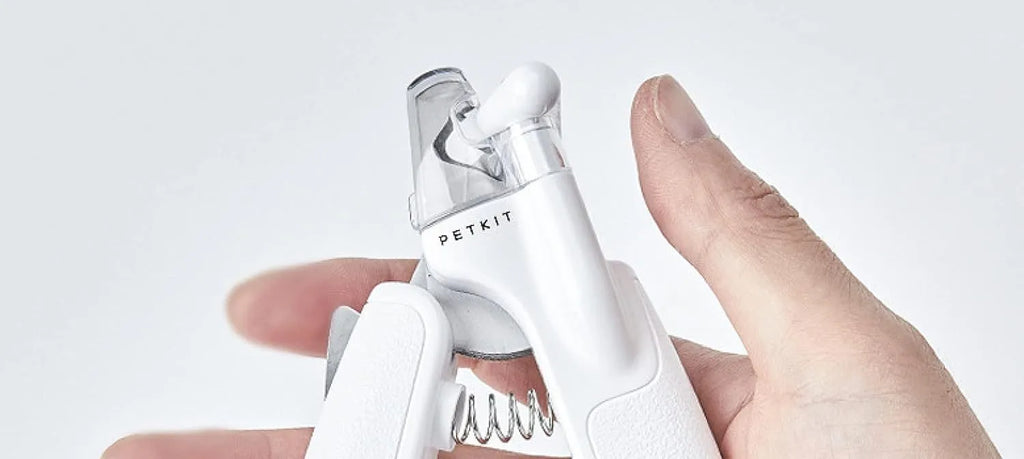 White LED pet nail clipper with a triangular blade, anti-splash guard, and leatherette handle.