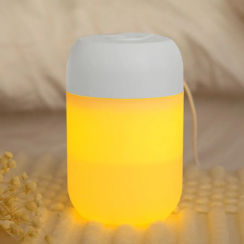 White cylindrical USB mini humidifier on desk with charging cable