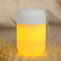 White cylindrical USB mini humidifier on desk with charging cable