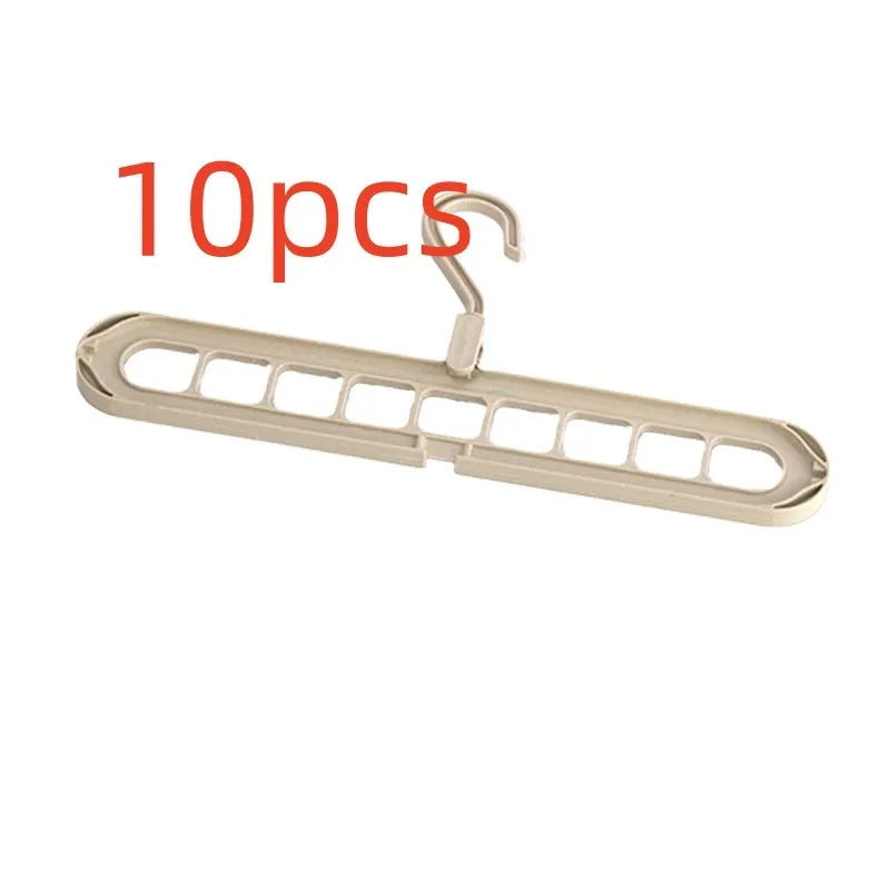 Green plastic folding clothes hanger with nine holes for organising trousers on a rack.