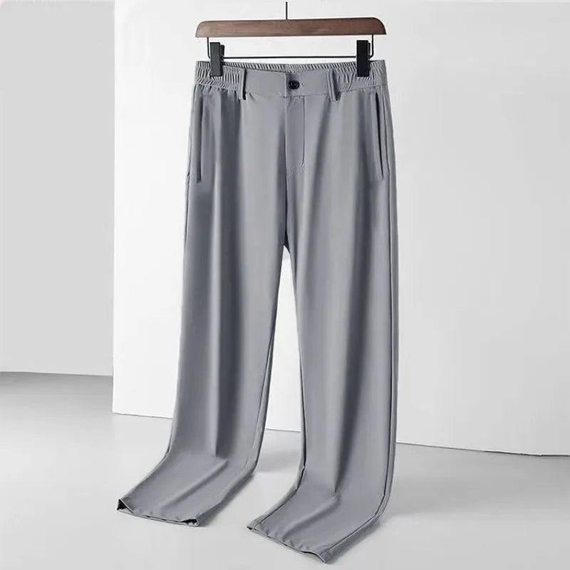 Man wearing black ice silk straight leg loose fit casual trousers with an elastic waistband