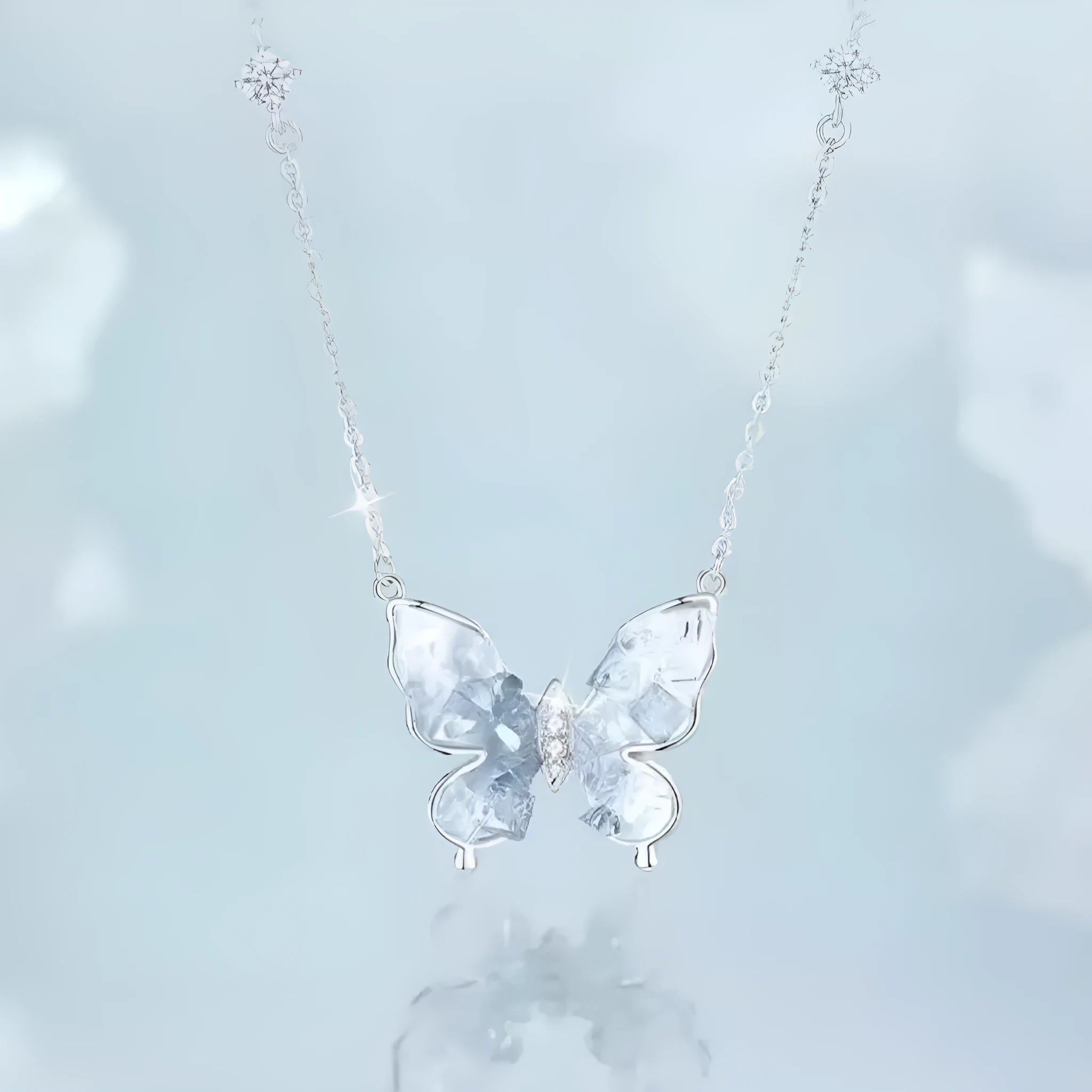 Close-up of a silver butterfly pendant necklace on an adjustable O-ring chain, showing detailed ice rain design.